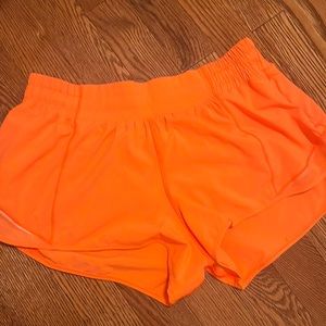 Lululemon highlight orange hottie hot low rise 2.5 inch shorts.